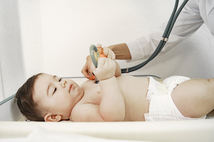 Doctor with stethoscope. Baby without clothes. Examination by a doctor.